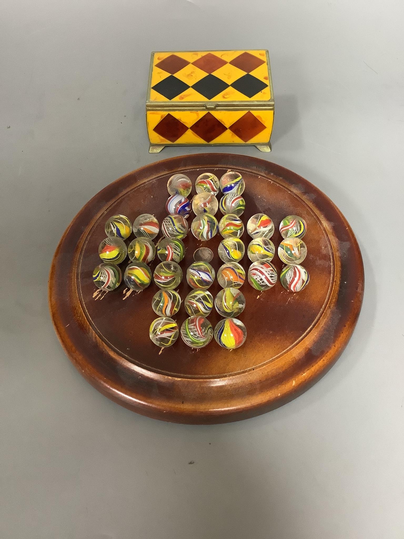 A mahogany solitaire board, together with a collection of 19th century glass marbles and a faux stone box